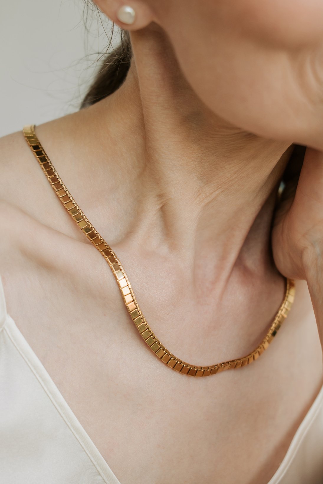 Old Woman Wearing a Minimalist Gold Necklace